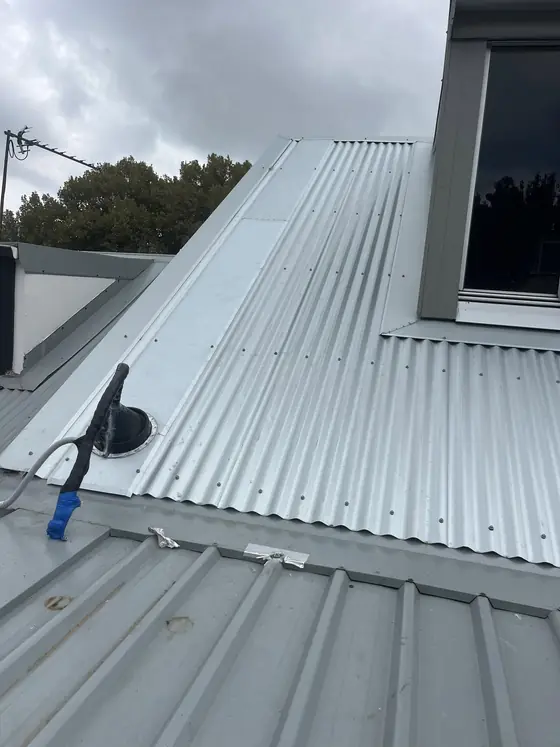 Back tray and Dektite flashing sealing an air-con pipe through a metal roof in Surry Hills