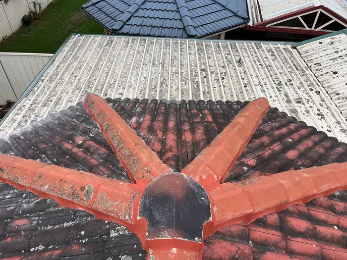 Terracotta hip and ridge caps freshly repointed where five ridges meet