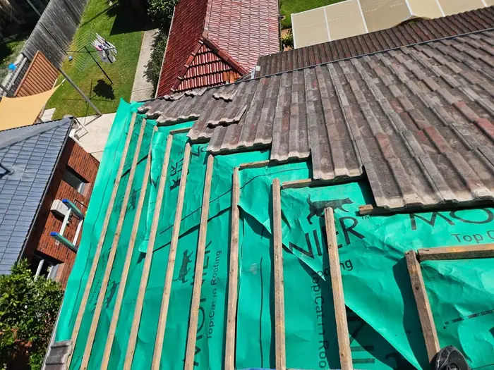 Tiles lifted to show new sarking and battens going down in Maroubra